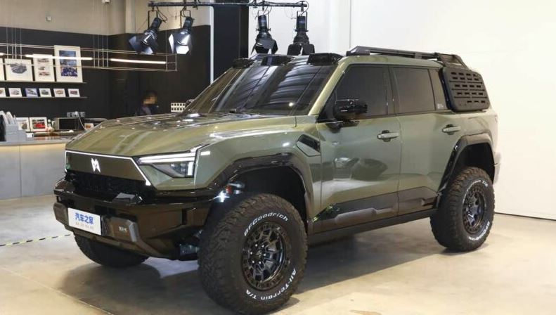 نمای جلو دانگ‌فنگ واریر M817شاسی‌بلند برقی و پیشرفته Dongfeng Warrior M817؛ طراحی جسورانه و فناوری پیشرفته جلوپنجره بزرگ و چراغ‌های روز هوشمند که هویتی مدرن و آینده‌نگر به Warrior M817 بخشیده است. نورپردازی لوگو و نوارهای LED روی جلوپنجره که علاوه بر زیبایی، دید بیشتری در شرایط سخت فراهم می‌کند. حسگرهای LiDAR روی سقف که نشان‌دهنده قابلیت‌های رانندگی خودران پیشرفته هستند. نمای جانبی؛ استحکام و آمادگی برای مسیرهای دشوار بدنه مقاوم با طراحی نظامی که دوام و قدرت خودرو را در شرایط سخت تضمین می‌کند. رینگ‌های ضدجداسازی و تایرهای AT برای کنترل بهتر در مسیرهای خاکی و سنگلاخی. نردبان‌های جانبی شناور و پنل‌های مشبک که امکان سفارشی‌سازی بیشتر را برای آفرودبازها فراهم می‌کند. KHODROZI.IR