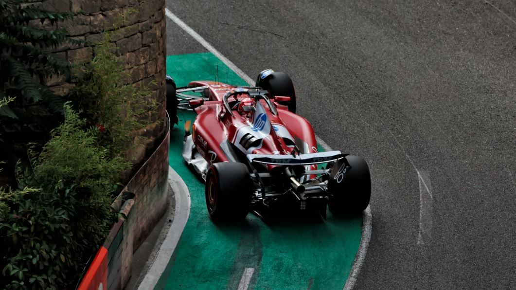 خودروی فرمول یک تیم فراری مدل SF-25 با رنگ قرمز در حال عبور از پیچ باریک شماره ۴ پیست شهری باکو در مرحله سوم تعیین خط گرند پری آذربایجان فرمول یک ۲۰۲۵، در بخش فرار سبز رنگ با دیوار سنگی در سمت چپ؛ لحظه‌ای حساس از رقابت تعیین خط F1 باکو با حضور رانندگان مطرح مانند مکس ورشتاپن، شارل لکلرک و اسکار پیستری |khodrozi.ir